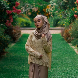 a woman standing proudly in a garden full of flowers